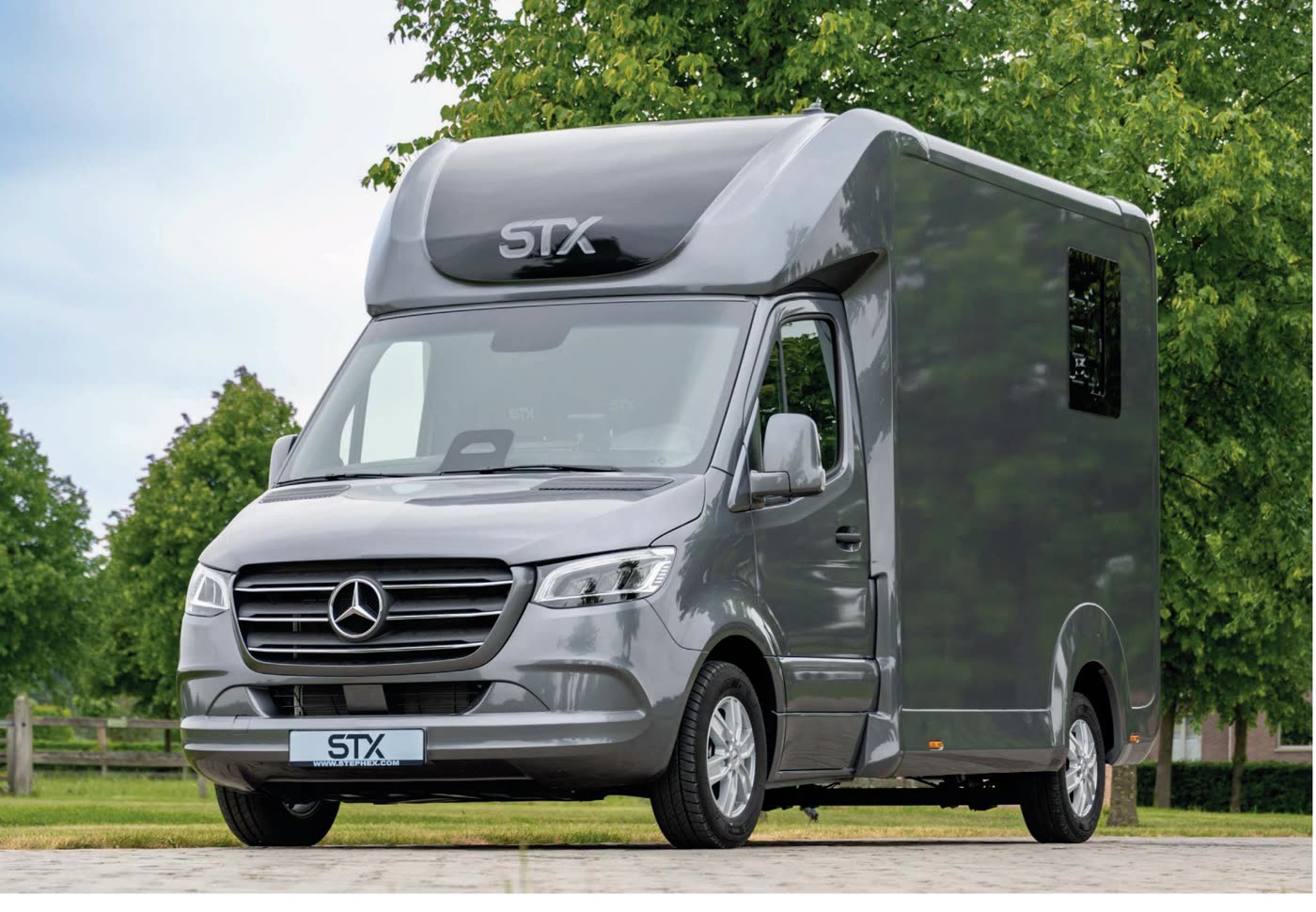 STX 2 Horse Mercedes Sprinter alvázon, 3/4-es elölnézet zöld fák előtt